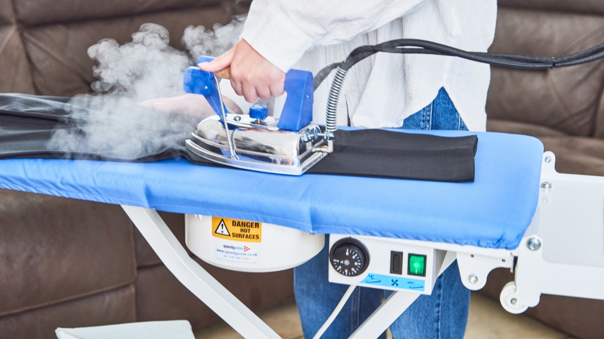 Commercial steam boiler and heated ironing table for a professional ironing service